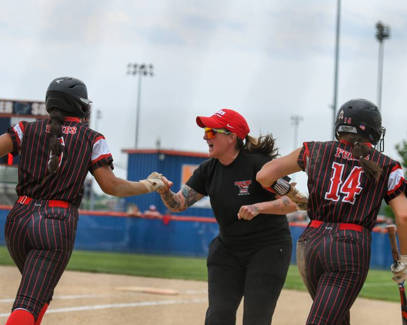 Yorkville’s coach celebrates with teammates Yorkville's Liv Lathen (5) and Rilee Petrusa (14) after both scoring a run during the sectional semifinal game on Tuesday June 3, 2025, held at Oswego High School.