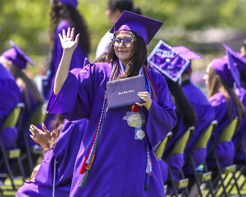 A new graduate waves to her family in the stands after receiving her diploma during the Plano High School Graduation ceremony Sunday, May 18, 2025  in Plano.