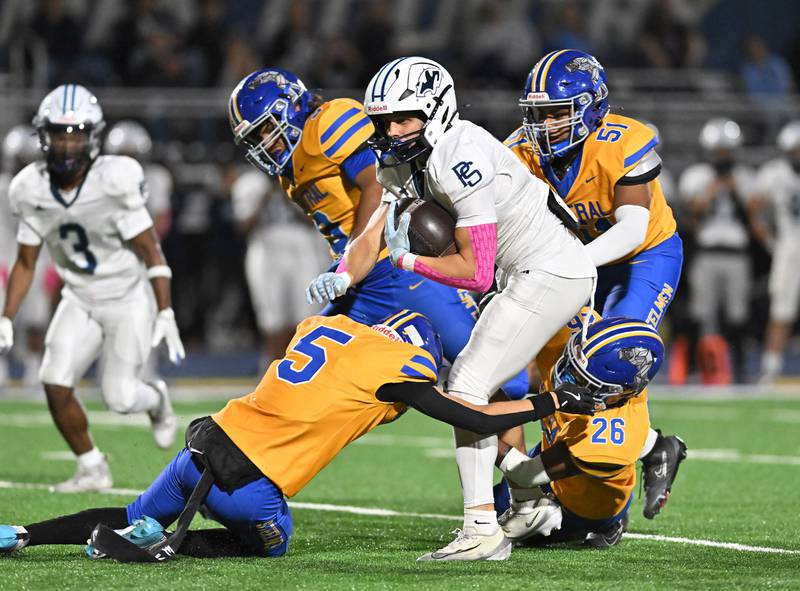 Plainfield South's Logan Weiss (10) get's tackle by Joliet Central's Victor Garcia-Cervantes (5) and Tra’vonte Nicks (26) during the conference game on Friday, OCT. 17, 2025, at Joliet.