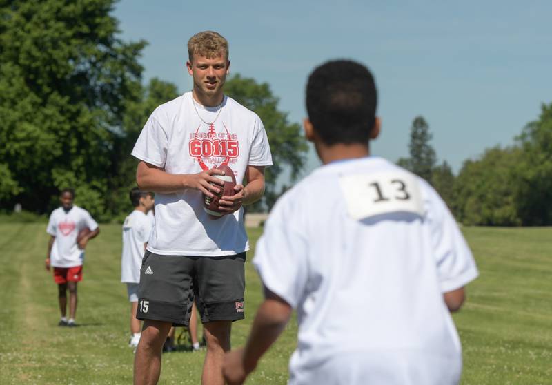 NIU's Cole Tucker works with youth during the Youth Pride FoundationÕs inaugural Legends of the 60115 Football Camp in DeKalb on Sunday, June 26, 2022.