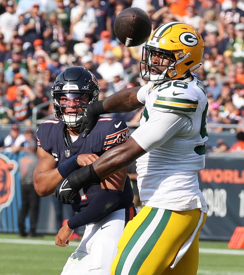 Chicago Bears quarterback Justin Fields gets rid of the ball just before being hit by Green Bay Packers defensive tackle Colby Wooden during their game Sunday, Sept. 10, 2023, at Soldier Field in Chicago.