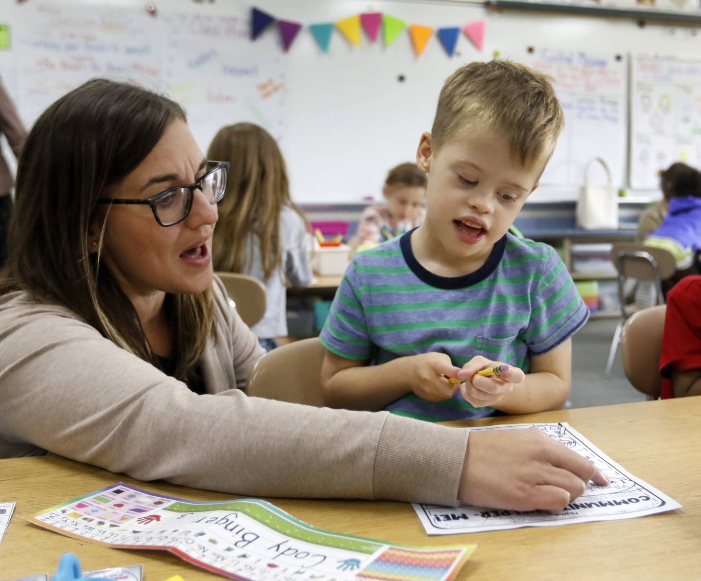 Teacher Jessica Weglarz helps Cody Binger, a first grader with Down syndrome with a class assignment about community helpers on Wednesday, Sept. 14, 2022, at Leggee Elementary School in Huntley. Binger will appear in a national video aimed at raising awareness of Down syndrome, set to be shown in Times Square on Saturday, Sept. 17. The video will include 500 adults and children with Down syndrome.