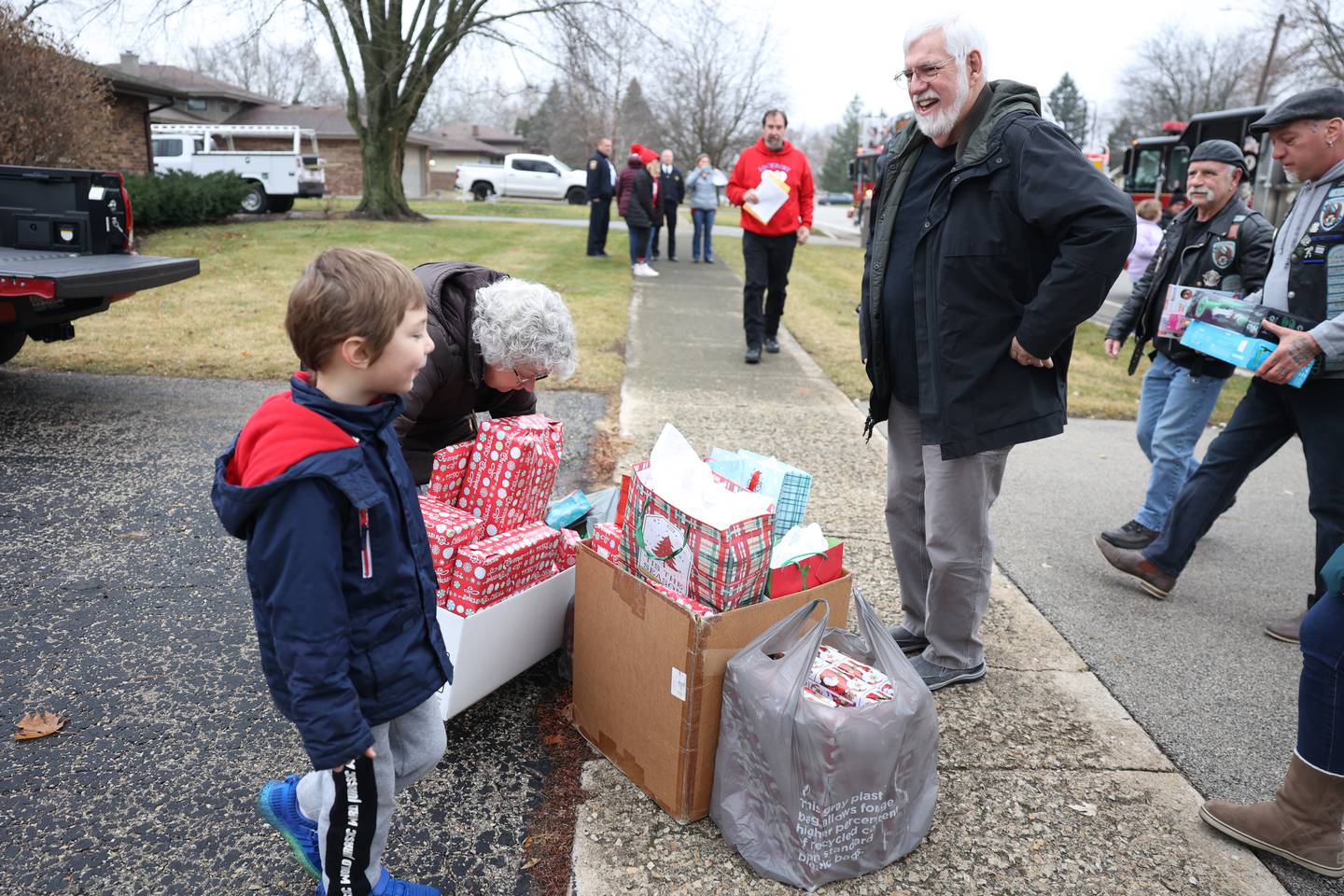 Gage Jenicek, 5, watches as volunteers deliver gifts to the Jenicek family on Saturday, Dec. 10, 2022, in Lockport.