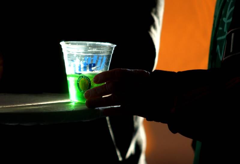 A festivalgoer reaches for green beer at the ShamROCKS the Fox Festival in McHenry Friday, March 17, 2023.