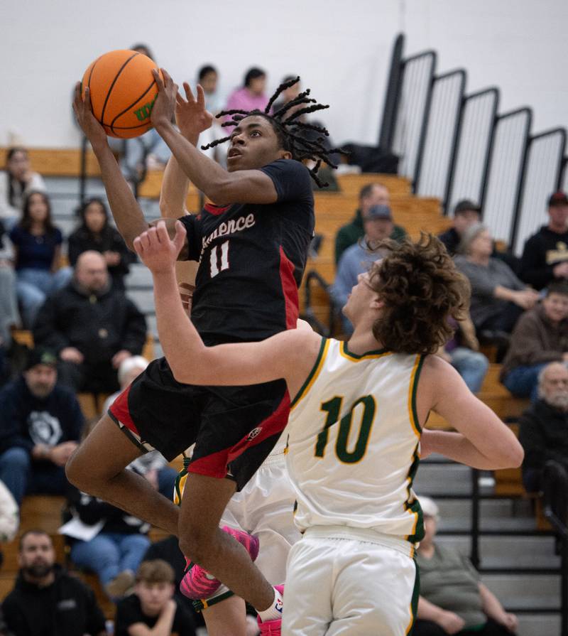 Momence's D'Angelo Hundley elevates for a shot as Grant Park's Tony Valerio, front, guards in a game on Friday, January 16, 2026.