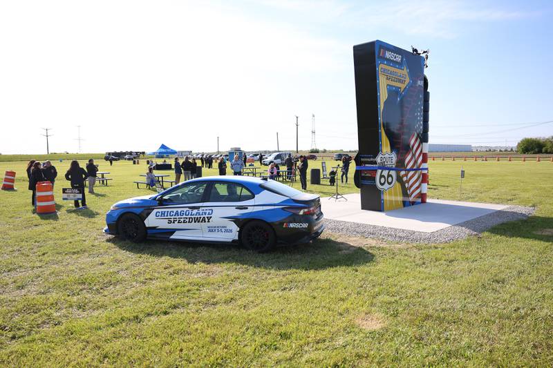 A small crowd gathers for the unveiling of the new Route 66 sculpture along South Chicago Street at the Route 66 Raceway on Tuesday, May 12, 2026 in Joliet.