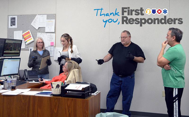 Rock Falls Police Department Citizen Police Academy participants Jodi Perez (left) of Rock Falls, Valerie Villaneda of Sterling and Brent Wright of Rock Falls, investigate a mock crime scene with Detective Sgt. Doug Wolber (right) during the group's April 3, 2024, meeting. The "victim" is played by police Officer Autumn Day.