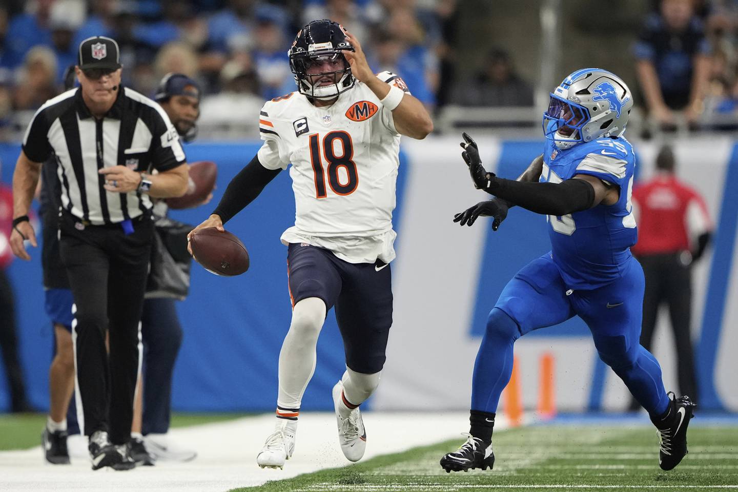 Chicago Bears quarterback Caleb Williams (18) runs past Detroit Lions linebacker Derrick Barnes (55) during the second half of an NFL football game in Detroit, Sunday, Sept. 14, 2025. (AP Photo/Ryan Sun)