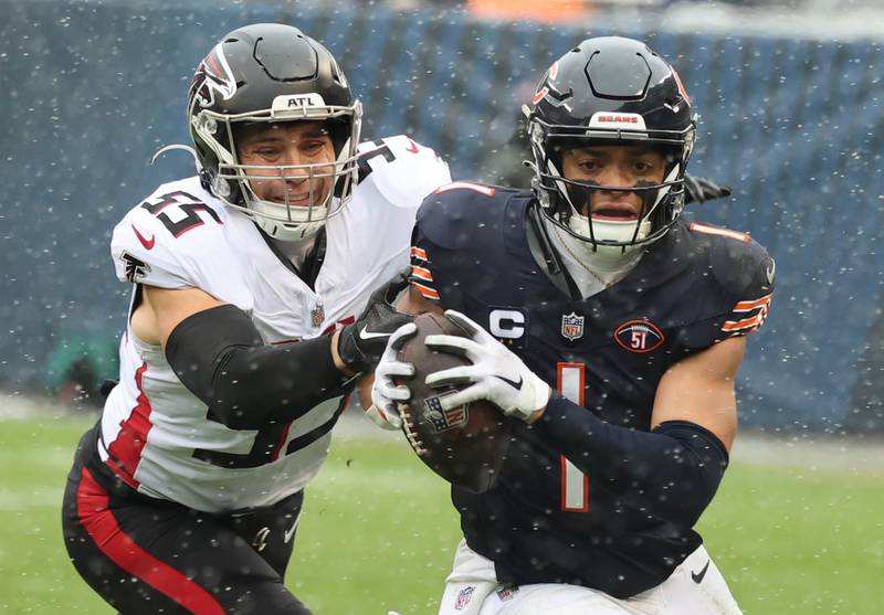 Chicago Bears quarterback Justin Fields gets past Atlanta Falcons linebacker Kaden Elliss for gain on a scramble during their game Sunday, Dec. 31, 2023, at Soldier Field in Chicago.