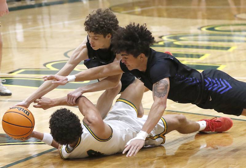Burlington Central's Ryan Carpenter (center) and Caden West (right) dive onto Crystal Lake South's Anthony Demirov as they try to get a loose ball during a Fox Valley Conference basketball game on Tuesday, Jan. 28, 2025, at Crystal Lake South High School.