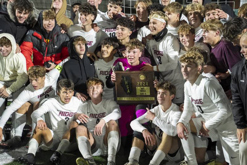 Prairie Ridge goalkeeper Christopher Zinevich holds the trophy as he celebrates with teammates and fans after beating Wauconda during the Class 2A Boys Soccer Sectional final on Friday, November 1, 2024 at Grayslake Central High School. Ryan Rayburn for Shaw Local