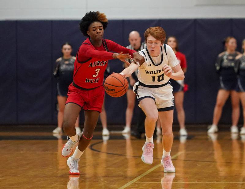 Oswego East's Noah Mason (10) steals the ball from West Aurora's Jayvyn Marion (3) during a basketball game at Oswego High School on Friday, Feb 2, 2024.