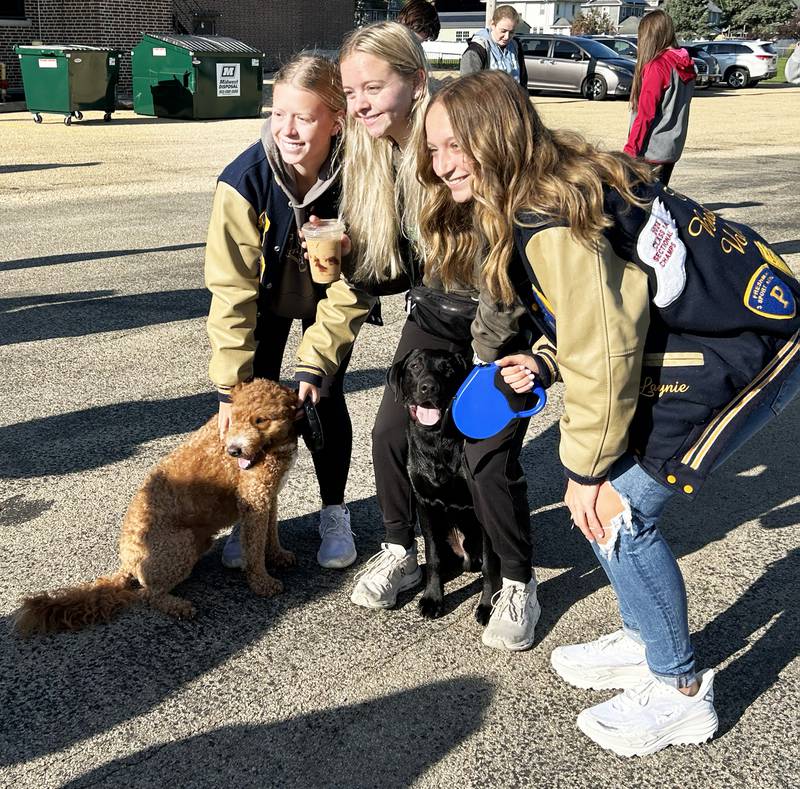 Carlee Grobe, Grace Miatke, and Laynie Mandrell, pose for a photo with Harley and Max, at the Doggy Dash on Saturday, Sept. 6, 2025. The event, organized by the Polo Student Council, raised money for a local animal shelter.