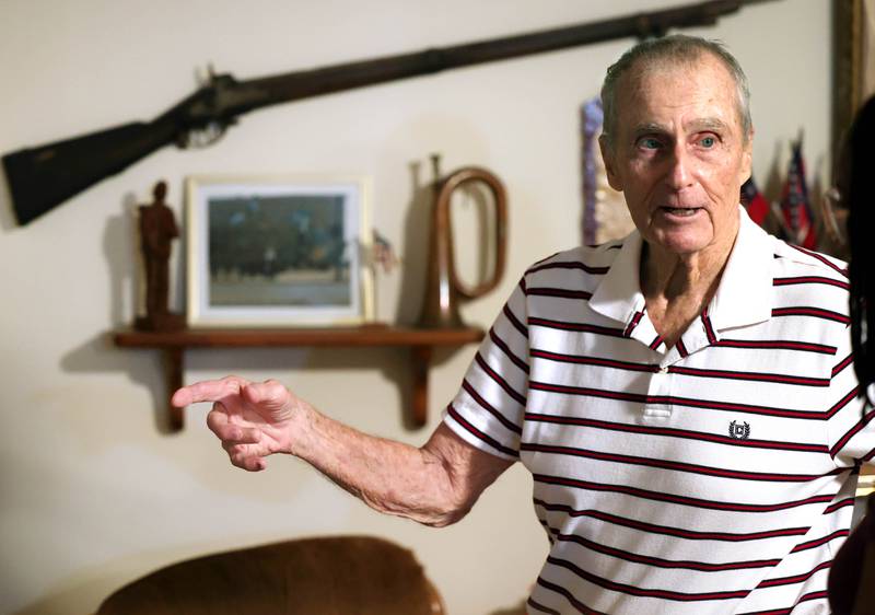 U.S. Army Veteran Jerry Busby talks Wednesday, Aug. 28, 2024, about some of the military and law enforcement memorabilia he has collected over the years that adorn the walls of his DeKalb home.