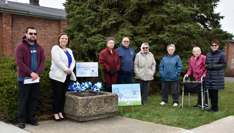 Pinwheels were placed in Polo to raise awareness about child abuse prevention. Pictured are (from left) Brandon Schaffer and Jessica Cash of Shining Star, Pat Kuhn, Mayor Doug Knapp, Diane Stern Miller, Gloria Bellows Schneider, Louise Hall and Sheila Dean, members of the Polo Women's Club.