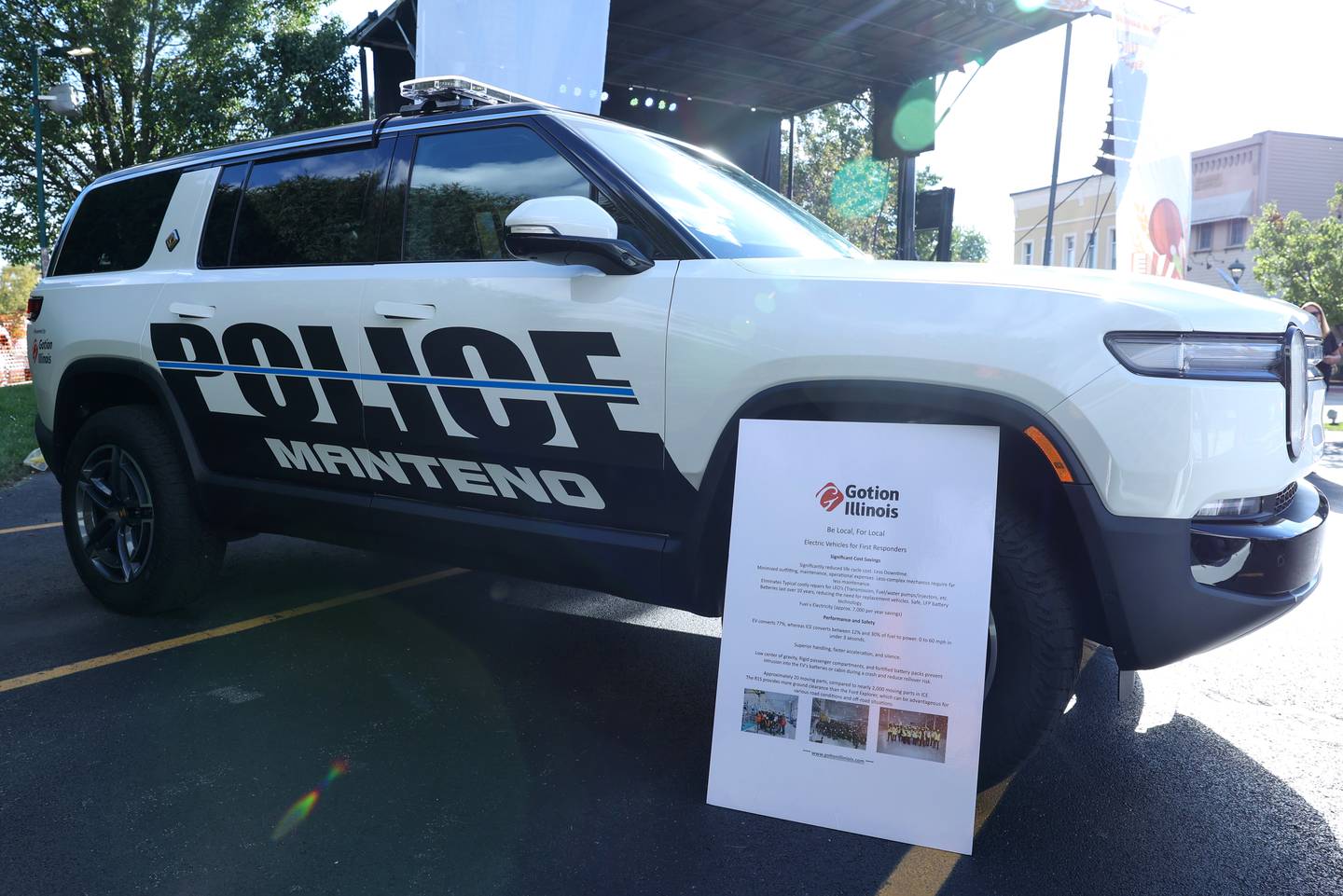 A poster sharing cost saving and performance facts accompanies the new Manteno Police Rivian EV squad car displayed in downtown Manteno on Thursday, Sept. 25, 2025, as Gotion, the lithium battery plant in Manteno, officially handed over the keys of the donated vehicle to the department.