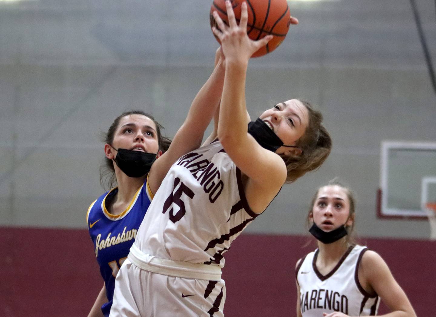 Marengo’s Gianna Almeida, front, and Johnsburg’s Macy Madsen, left, battle for a rebound during girls varsity basketball action in Marengo Thursday night. Marengo’s Emily Kirchhoff, right, keeps an eye on the action.