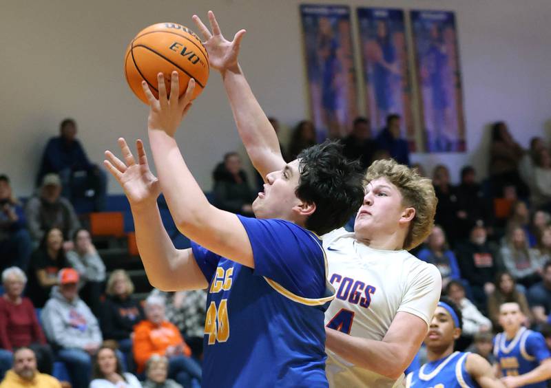 Aurora Central Catholic's Braden Dillon gets a layup in front of Genoa-Kingston's Cody Cravatta Monday, Feb. 23, 2026, during their IHSA Class 2A regional quarterfinal at Genoa-Kingston High School.