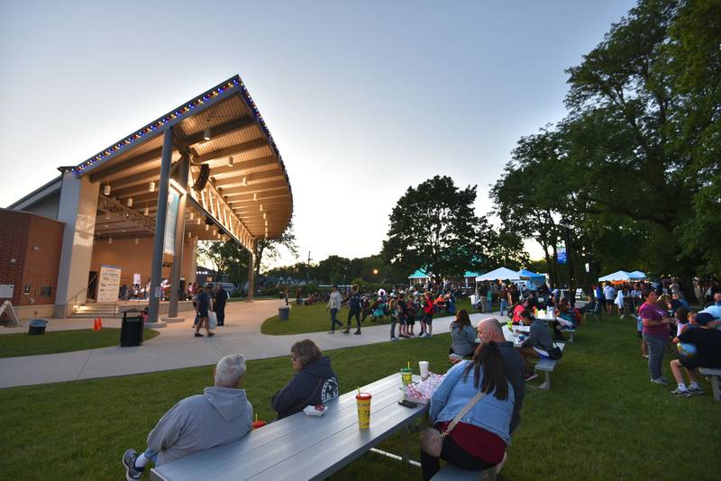 People enjoy a perfect summer evening in Memorial Park at the Cream of Wheaton summer festival in downtown Wheaton on Thursday, May 30, 2024.