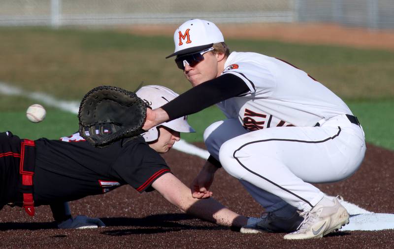 McHenry’s Owen Micklinghoff, right, fields a pick-off toss as Huntley’s Ryan Dabe scrambles safely back to first base in varsity baseball at McHenry Friday night.