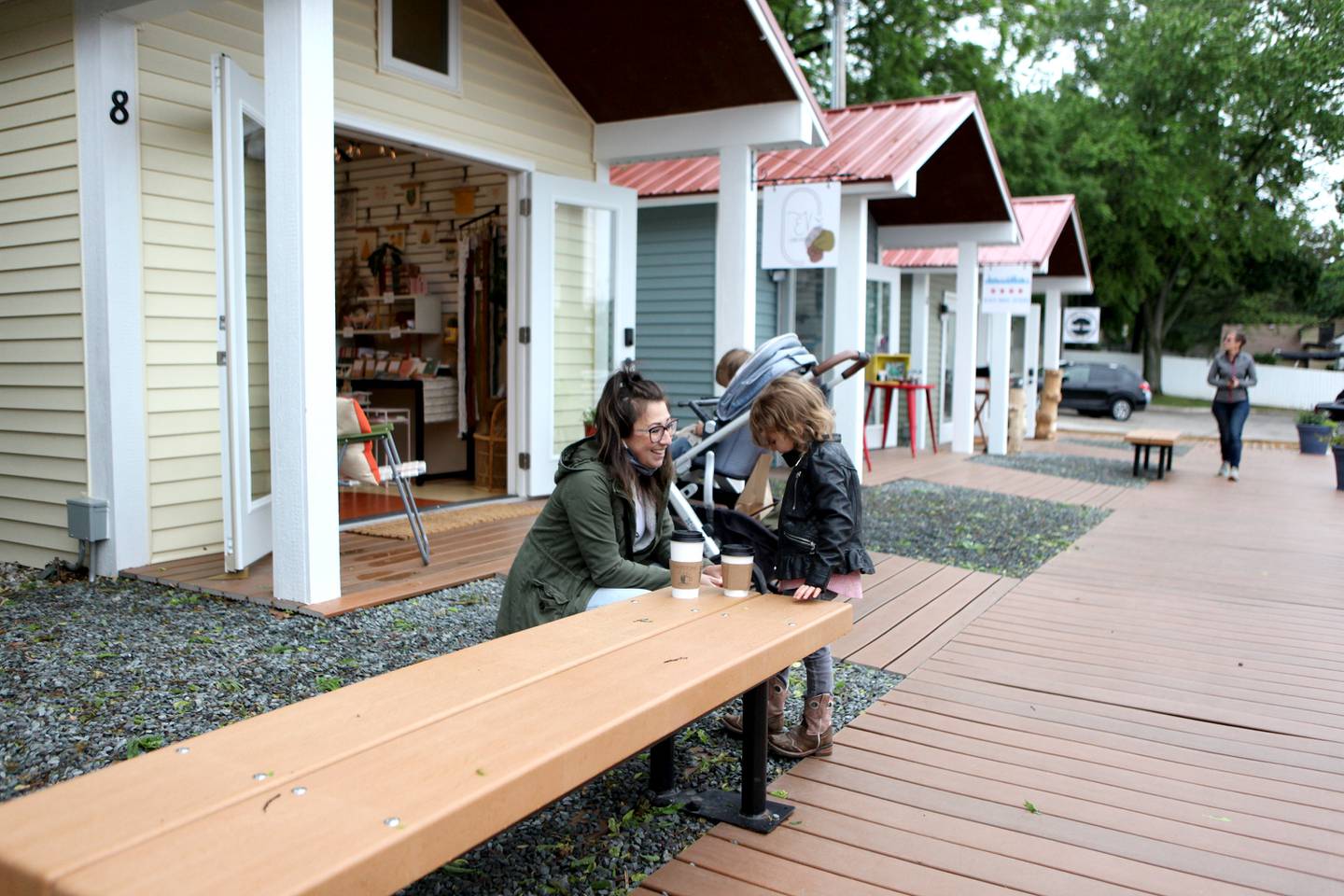 Stephanie Saltigerald helps Lola Jensen, 4, outside the Batavia Boardwalk Shops during opening day Friday, May 28, 2021.