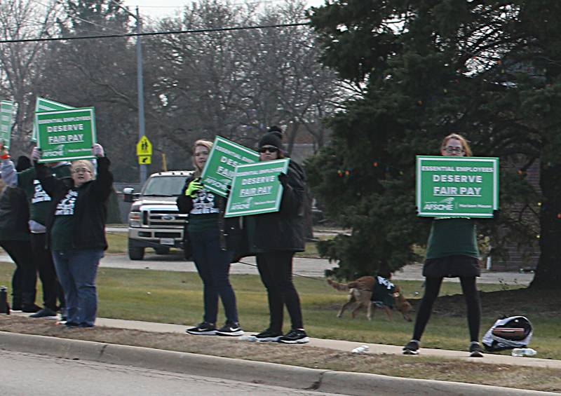 Horizon House employees hold signs reading "deserve better pay" outside of the Horizon House on Thursday, Dec. 8, 2022 in Peru.