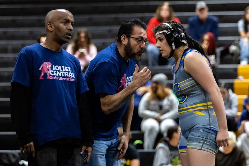 Joliet Central’s coaching staff chat with Leilani Robles during a break in the 155 pound match against Joliet West at Joliet West on Jan. 12, 2026.155