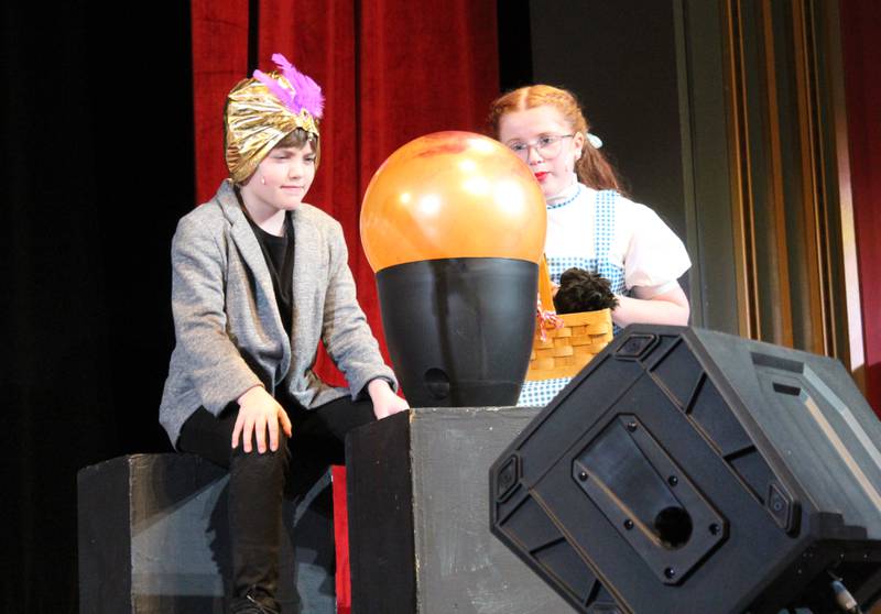 Professor Marvel/the Wizard of Oz (Kaelynn Johnson) and Dorothy Gale (Karsyn Stewart) gaze into the crystal ball right before Dorothy's voyage to Oz on Friday, March 22, 2024, during the Streator Elementary Schools production of "The Wizard of Oz – Youth Edition" at Streator High School.