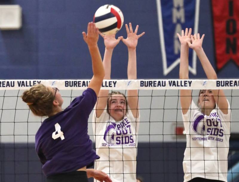 Bureau Valley senior Emma Stabler hits against Princeton's Karsyn Brucker (left) and Chrissy Sierens Tuesday night at the Storm Cellar.