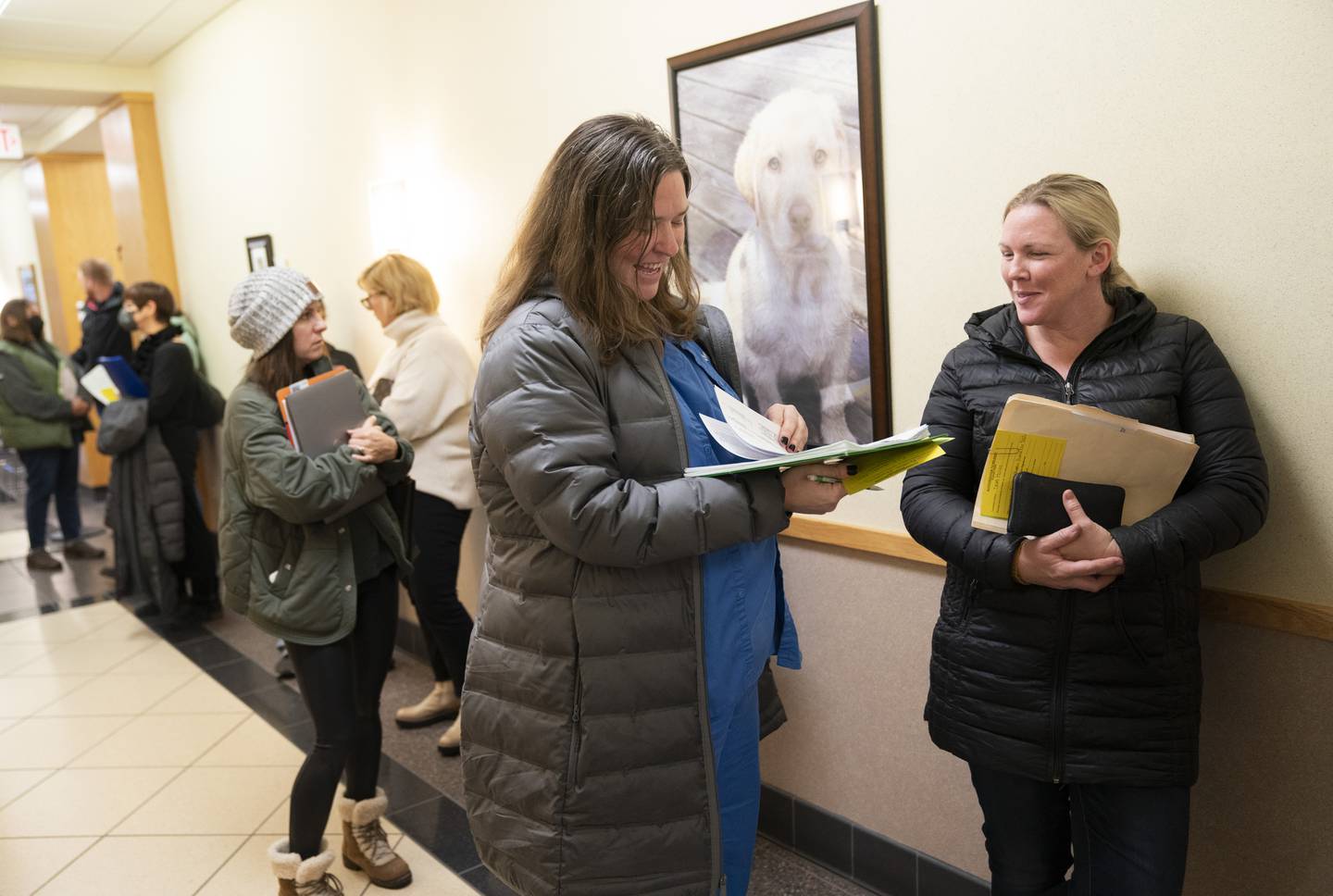 Candidates Kristina Konstanty, center, running for the Community School District 300 school board, and Dawn Holian, right, running for Richmond-Burton High School District 157 board, wait in line on Monday, Dec. 12, 2022, the first day area school board candidates could file for the April election, at the McHenry County Administration Building in Woodstock.