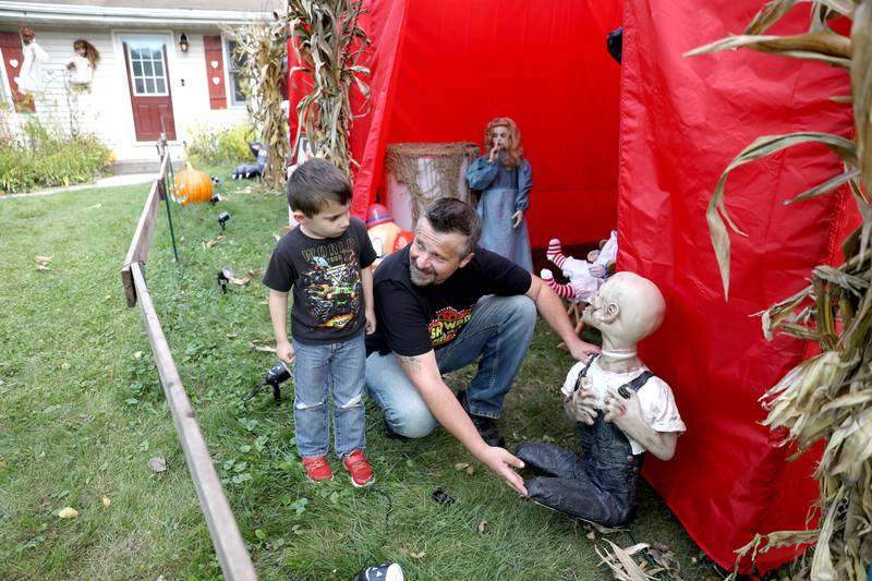 Tommy Nybo, with his 5-year-old son, Christian, has an expansive Halloween display in the front yard of his Downers Grove home.