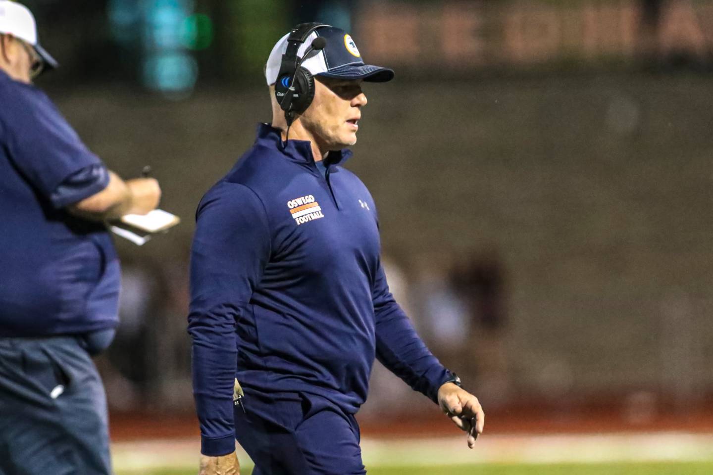 Oswego football coach Brian Cooney walks the sidelines during a game this season.