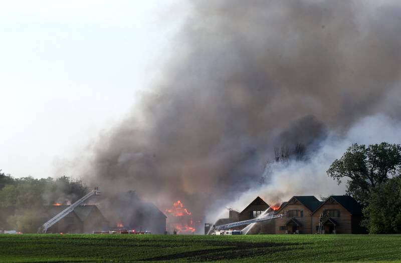 Flames emit from several cabins at Grand Bear Resort as firefighters work to extinguish the blaze. Strong winds pushed the flames to neighboring cabins.