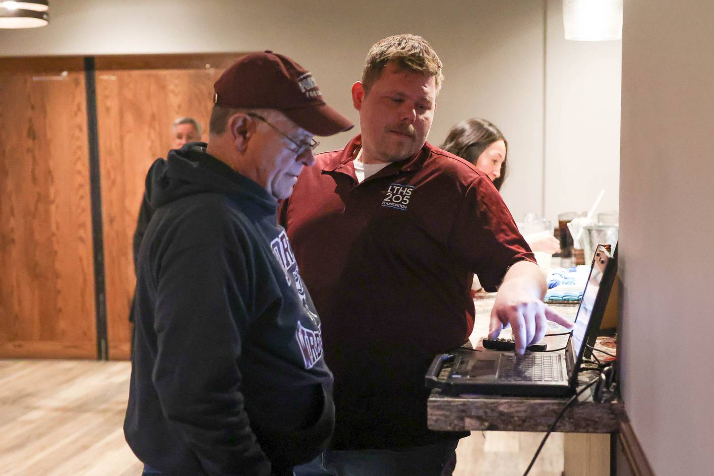 Lockport Township High School District 205 referendum committee members Rob Cromholm, left, at Tim Russ, look at the early vote results at a watch party at Coom’s Corner on Tuesday, March 19 in Lockport.