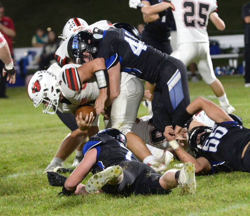 Forreston's Evan Boettner (4) is tackled by Eastland-Pearl City defenders on Friday, Sept. 20, 2024 in a NUIC Conference game at Pearl City.