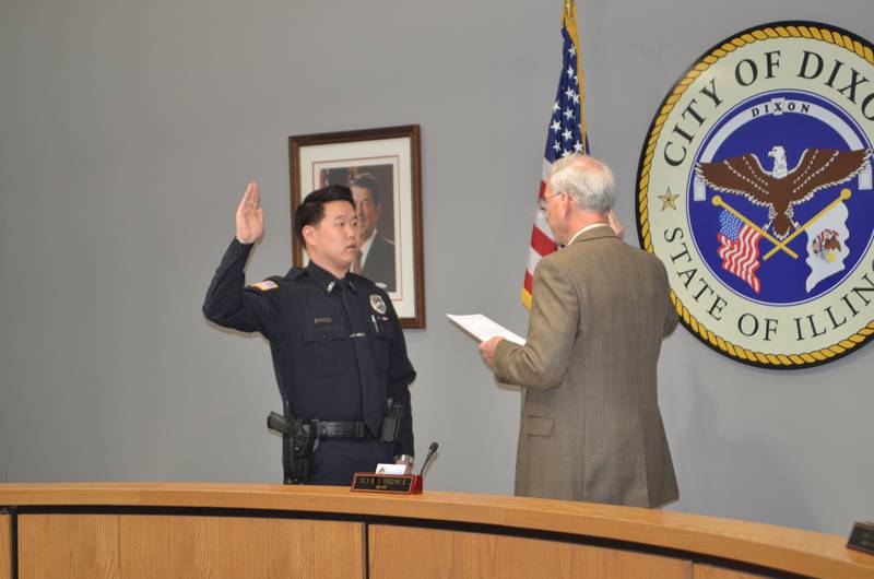 Dixon police officer Garrett Morhardt (left) takes the oath of office, as administered by Dixon Mayor Glen Hughes, on Monday night at Dixon City Hall.