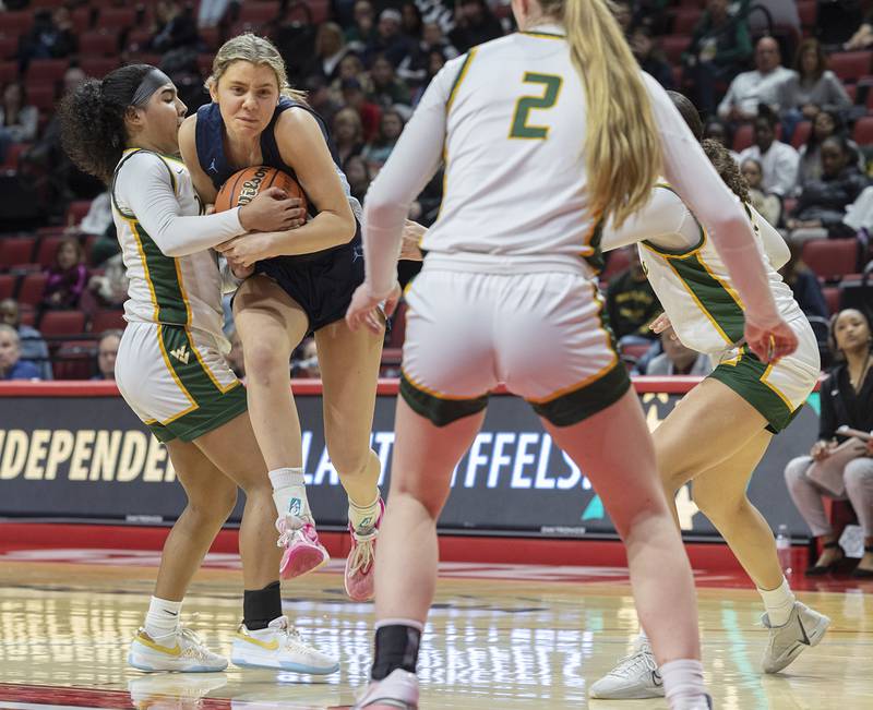 Nazareth Academy’s Stella Sakalas is held up by Waubonsie Valley’s Arianna Garcia Friday, March 1, 2024 in the girls basketball 4A state semifinal at CEFCU Arena in Normal.