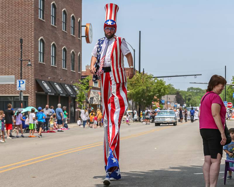 A stilt performer from the Lauren Underwood camp at the annual PrairieFest parade in downtown Oswego. June 18, 2023.