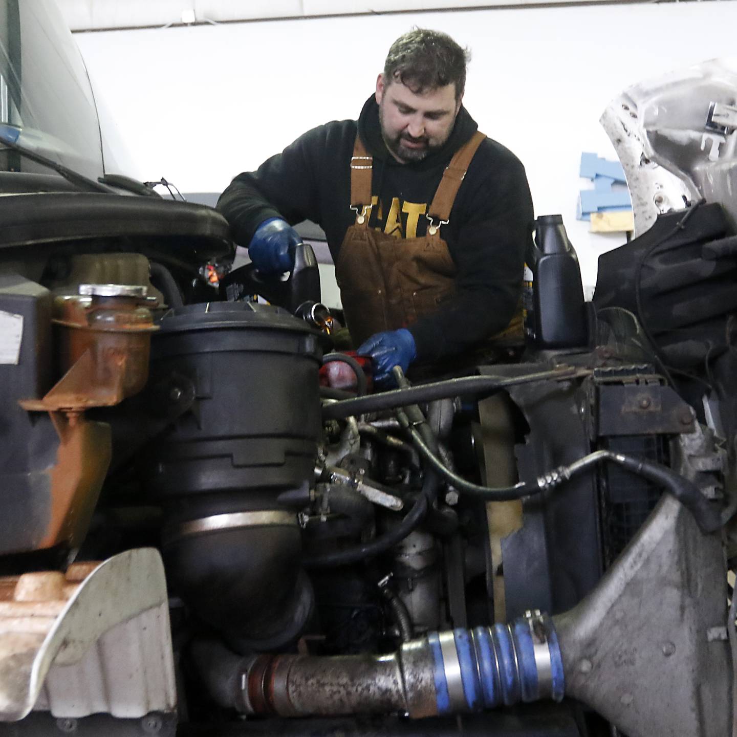 Andy Linic, the shop manager at Basic Logistics in Crystal Lake, performs maintenance on one of the company’s trucks on Friday, March 31, 2023, before it is used to make a delivery.