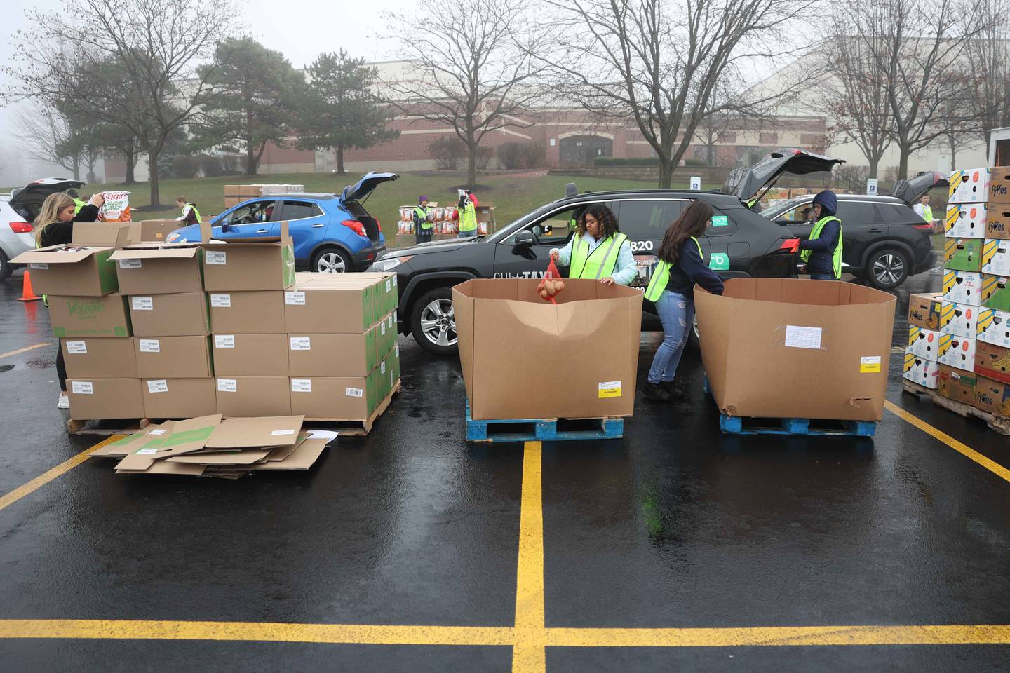 Volunteers load vehicles with food during ShareFest at Lockport Township High School East campus on Sunday, Dec. 15, 2024.