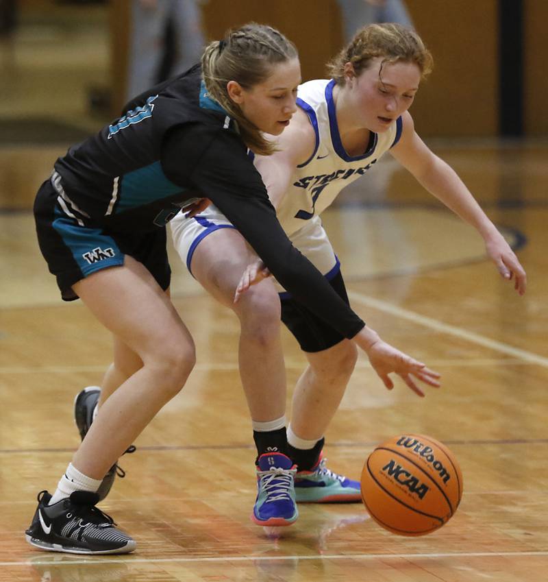 Woodstock North's Jadyn Grismer and Woodstock's Keira Bogott battle for a loose ball during a Kishwaukee River Conference basketball game on Friday, Jan. 10, 2025, at Woodstock High School.