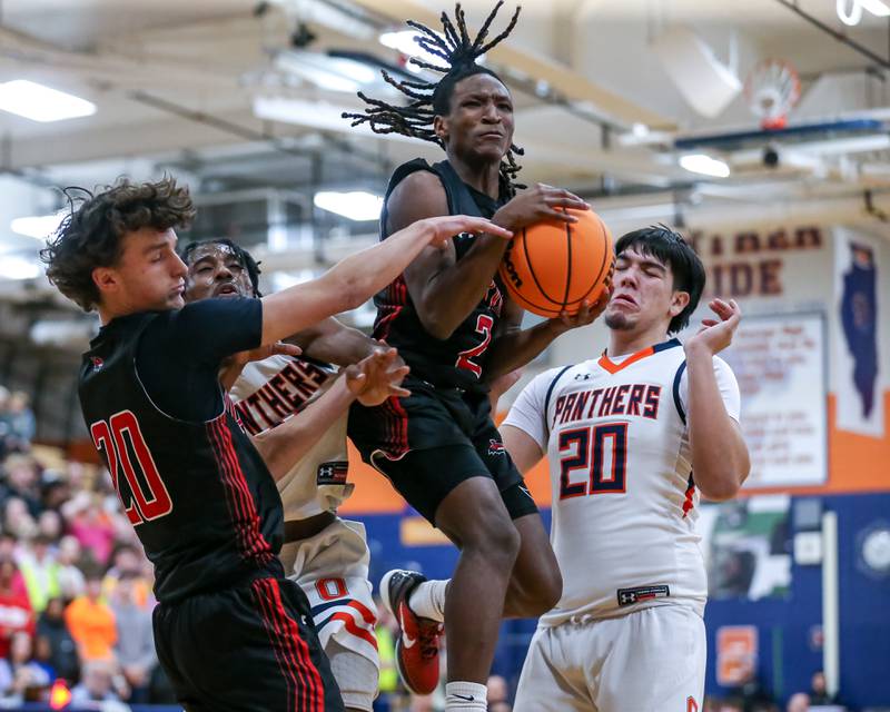 Yorkville's Alonn Flint (2) grabs a rebound during their basketball game between Yorkville at Oswego, Tuesday Dec 10, 2024 in Oswego.