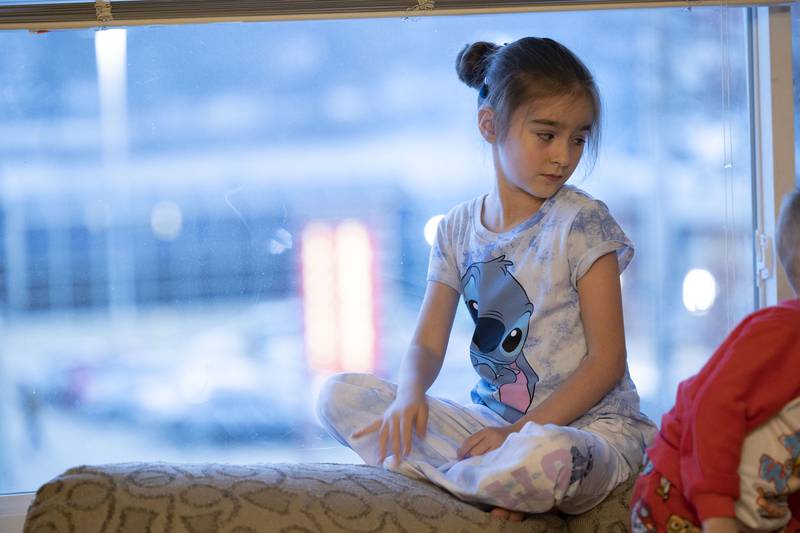 Nastya, 7, sits in the window of the apartment looking over an area of Dixon. Once the family made contact with a local group in Dixon, it took just a couple month to move the family over.