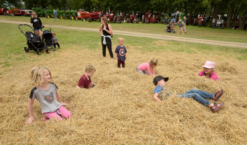 Kids play in a hay pile during the Annual Sycamore Steam Show in Sycamore on Friday, Aug. 12, 2022.