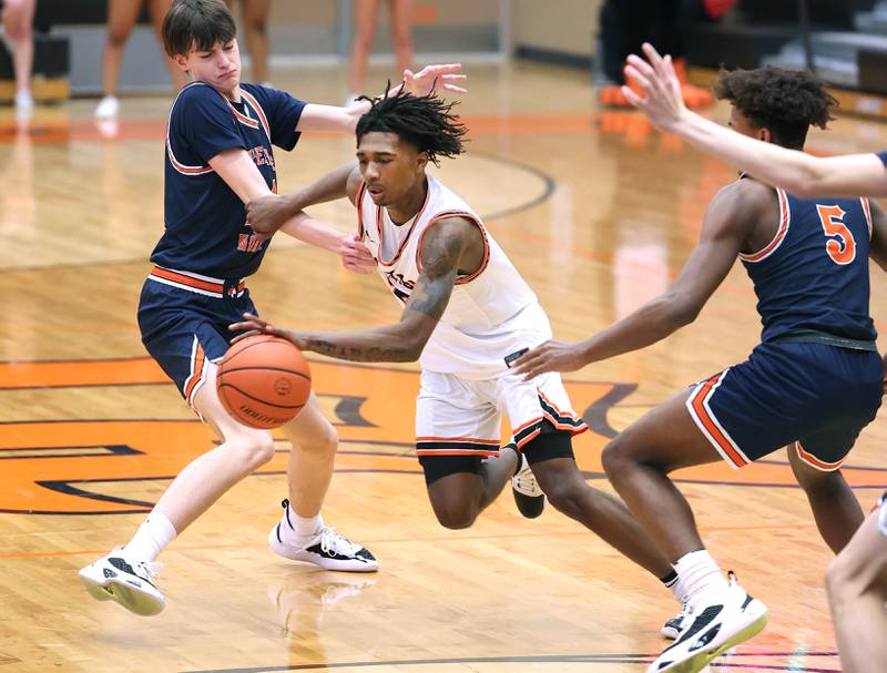 DeKalb's Darrell Island drives between two Naperville North defenders during their game Monday, Jan. 30, 2023, at DeKalb High School.