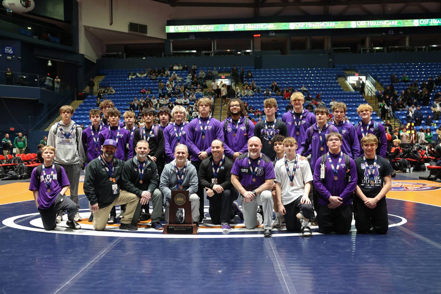 Dixon wrestlers and coaches pose with the IHSA Class 1A Dual Team State third place trophy on Saturday, Feb. 28, 2026.