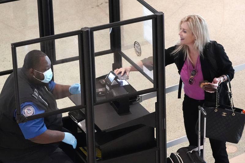 A traveler makes their way through a security ID and ticket check at Love Filed in Dallas, Tuesday, April 19, 2022. The major airlines and many of the busiest airports dropex their requirements after a Florida judge struck down the CDC mandate and the Transportation Security Administration announced it wouldn't enforce its 2021 security directive. (AP Photo/LM Otero)