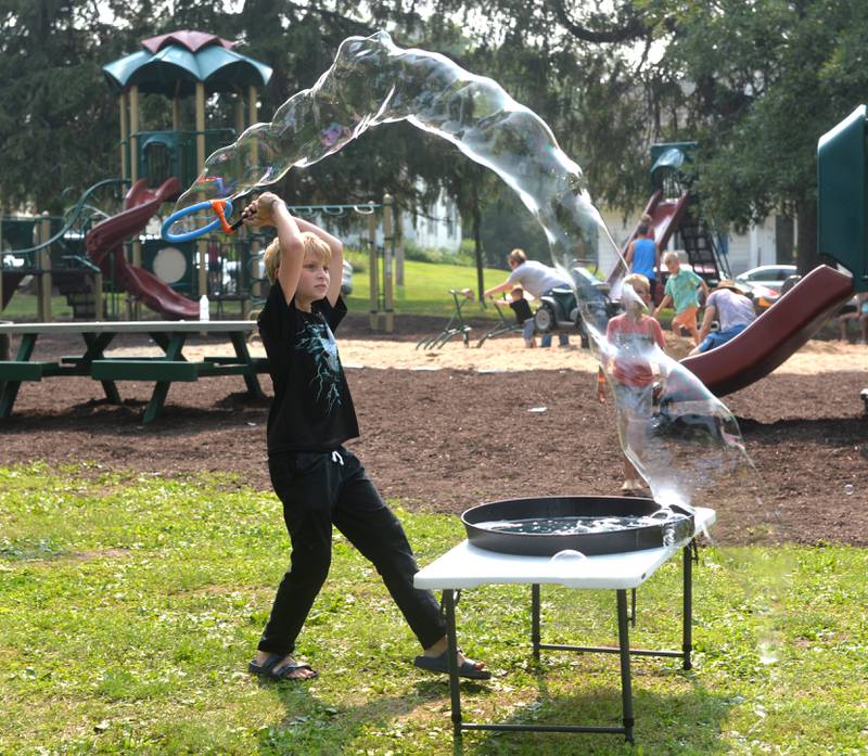 Wayne Bawinkel, 11, of Duth Dakota of Forreston, makes a big bubble at Jason Kollum's "Big Bubble Time' bubble event at Ben Miller Park during German Valley Days on Saturday, July 15, 2023.
