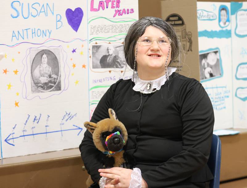 Logan Cambell, a sixth grade student at Logan Jr. High School, poses next to her Susan B. Anthony poster during a live Wax Museum on Thursday, Feb. 26, 2026 at Logan Jr. High School in Princeton.