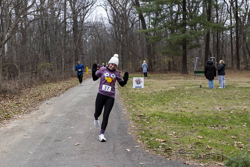 Supporters cheer on a runner Thursday, Nov. 28, 2024, during St. Anne’s Turkey Trot 5K.